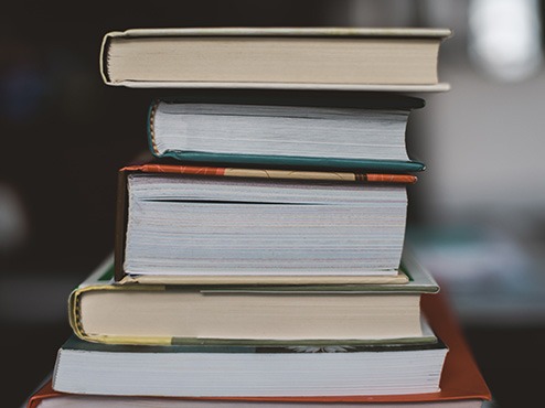 Books stacked on a table with a blurry background.